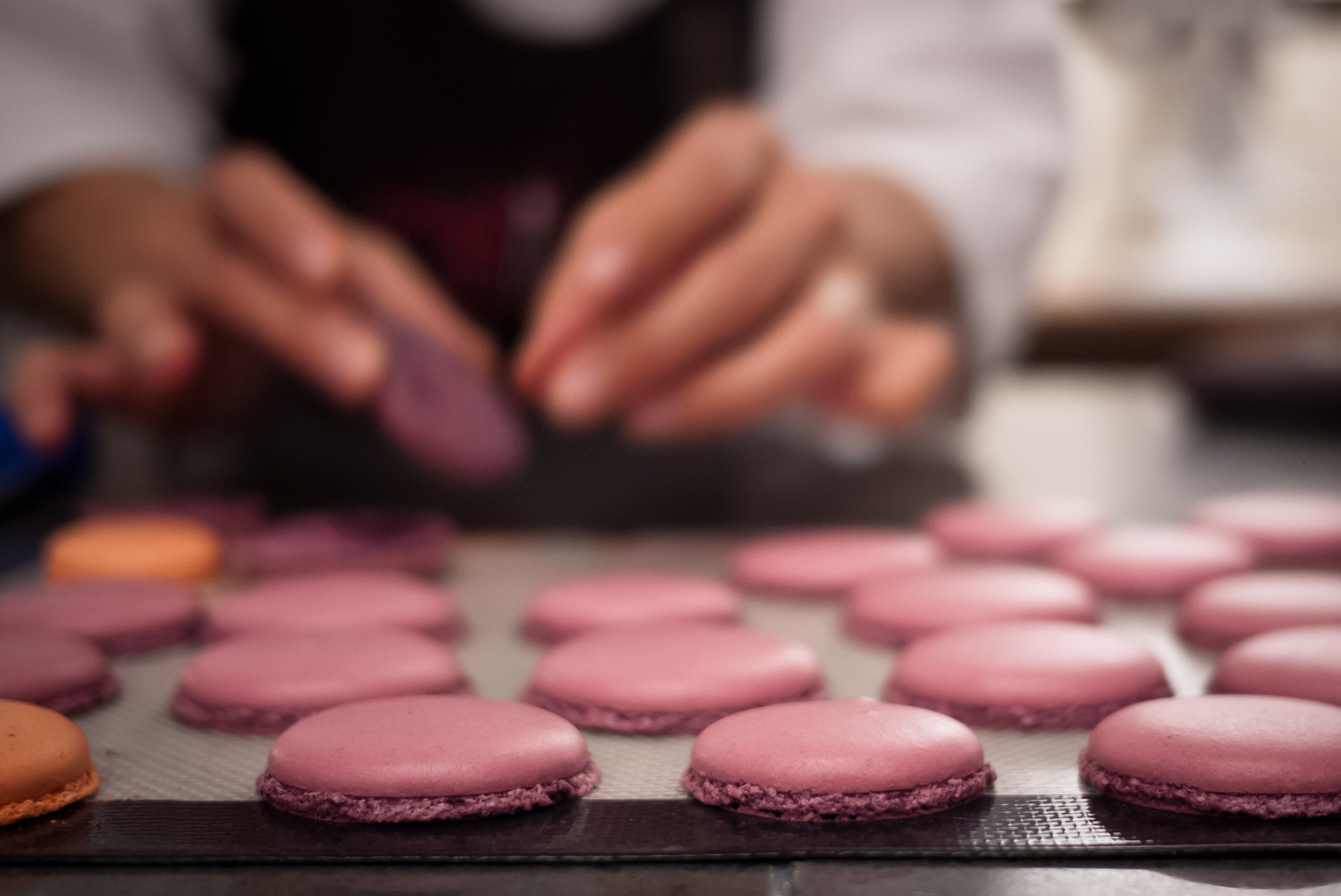 Baker placing macaron cookies on sheet